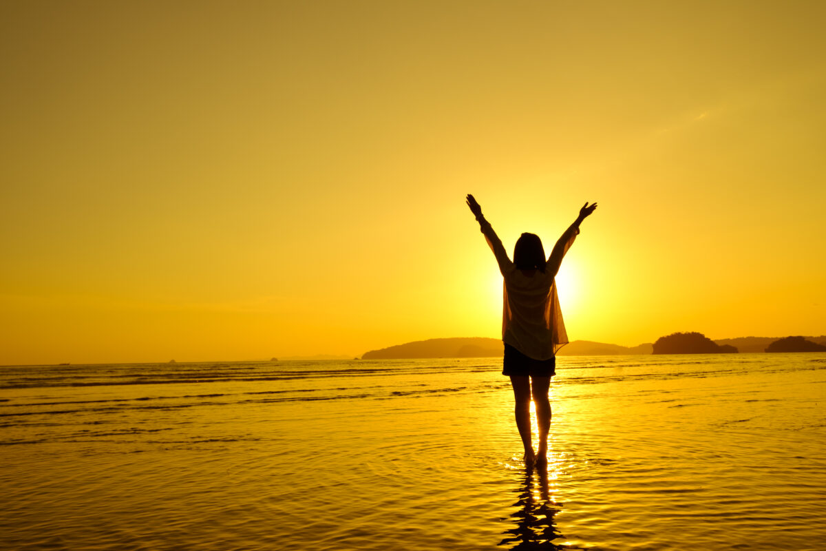 Relax Woman jumping sea on the beach Sunset silhouette,Happy Vacation Holiday Concept.